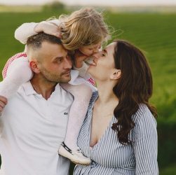 A delightful family moment captured in a lush scenic field, portraying love and happiness.