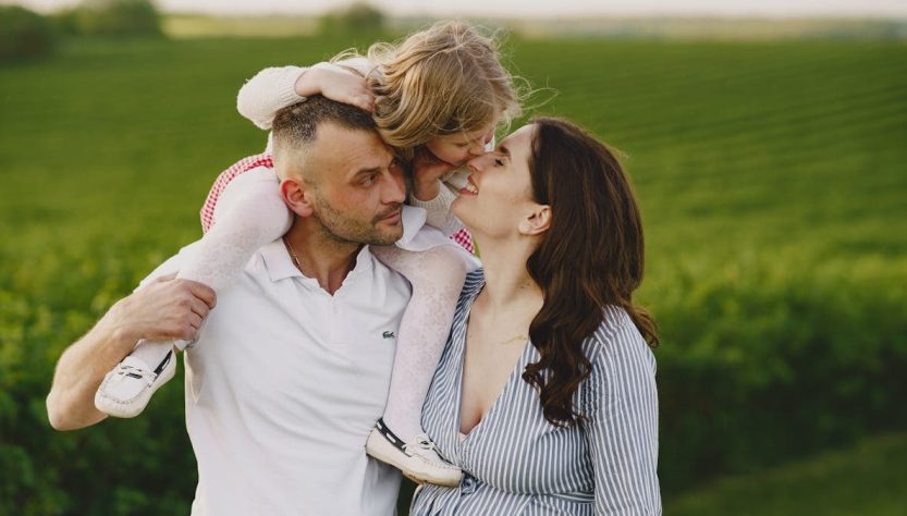 A delightful family moment captured in a lush scenic field, portraying love and happiness.
